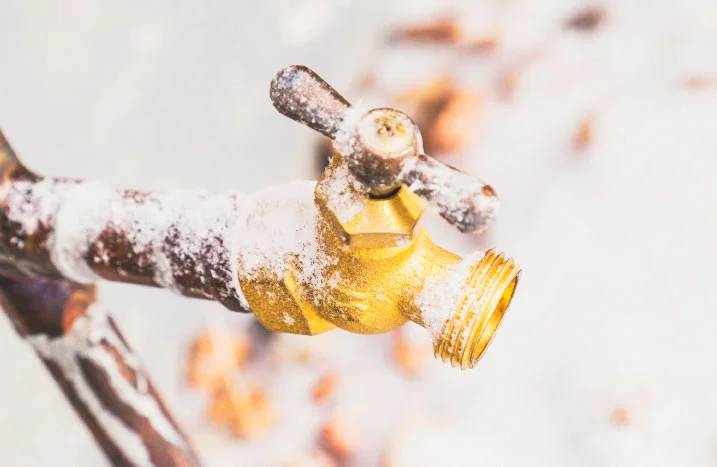 Wasserhahn mit Schnee bedeckt